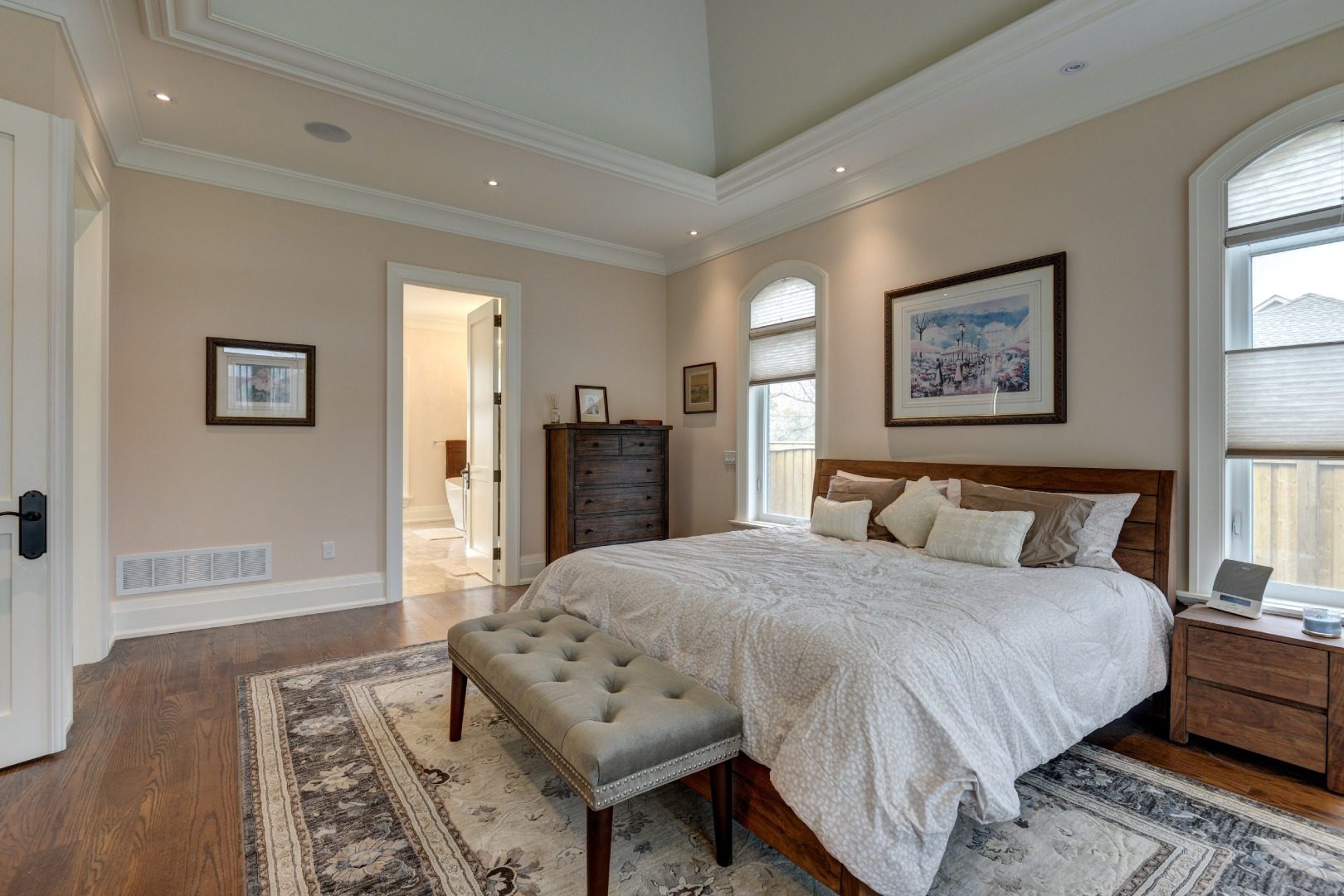 Bedroom with white sheets and large rug